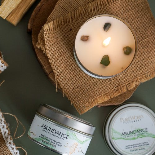 Abundance Sandalwood candle in a metal tin with jade crystal, promoting tranquility and prosperity; clean burn for 10 hours.