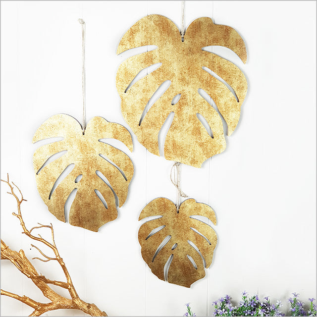 Antique gold textured ACM wall art set featuring three monstera leaves, perfect for indoor and covered outdoor decor.