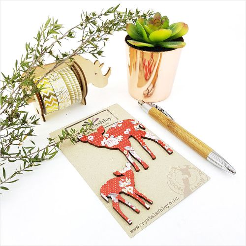 Charming Bambi wall art with red floral accents, perfect for brightening nurseries and children's rooms.