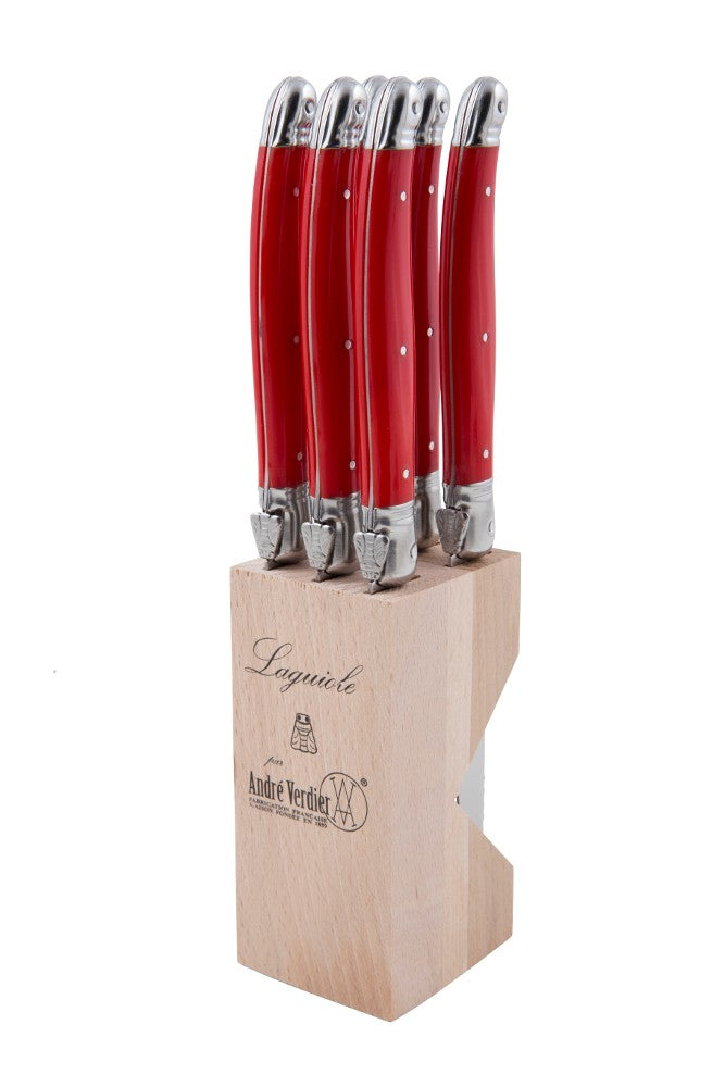 Set of 6 red Laguiole steak knives in a wooden block, featuring handcrafted stainless steel blades and resin handles for comfort.