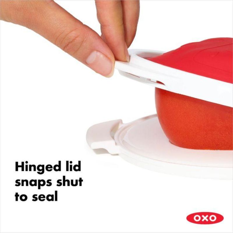 Silicone tomato saver with a sturdy base and hinged lid for storing cut tomatoes, promotes freshness and eco-friendly living.