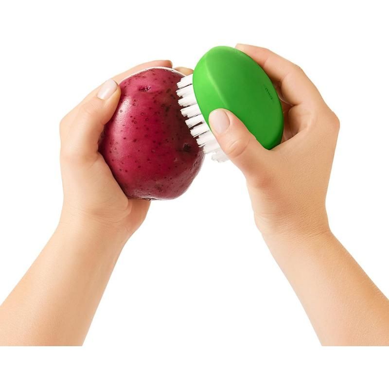 Durable OXO Good Grips Vegetable Brush with nylon bristles for cleaning potatoes and carrots, featuring a comfortable grip.