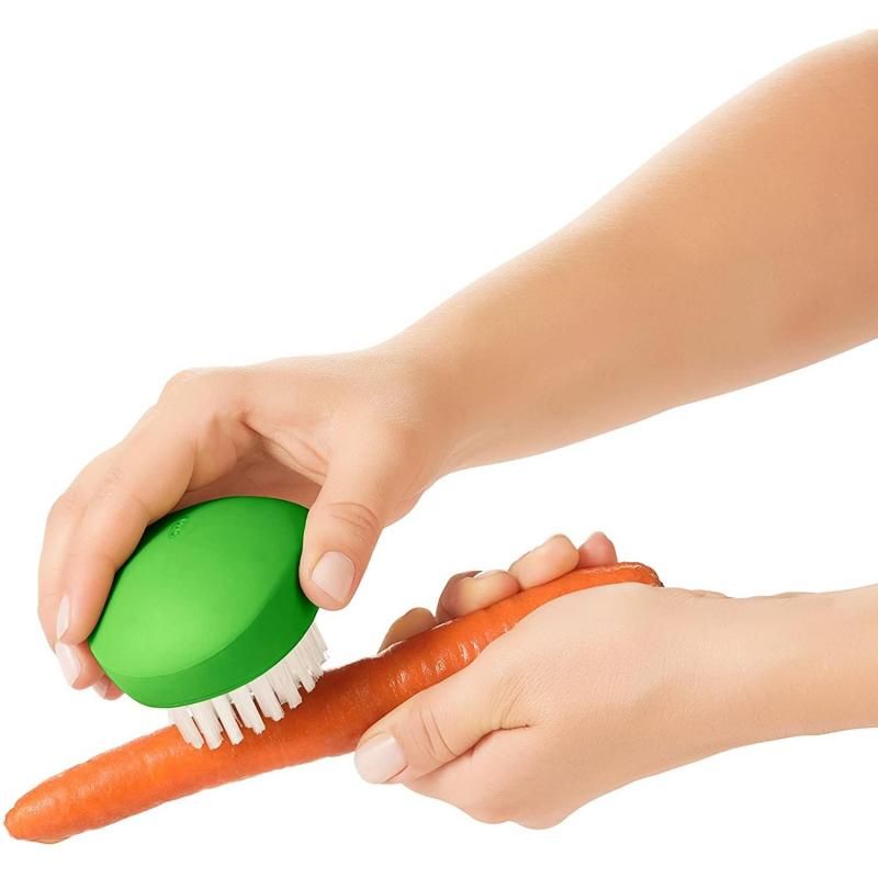 Durable OXO Good Grips Vegetable Brush with flexible grip and nylon bristles for easy cleaning of potatoes and carrots.