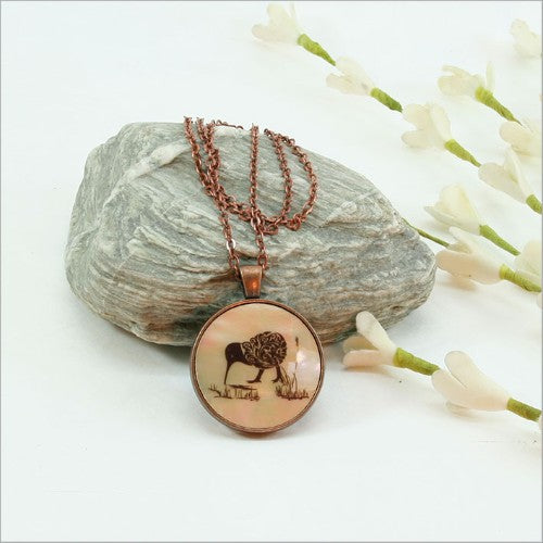 Elegant filigree kiwi pendant necklace on mother of pearl, 30mm diameter, 75cm chain, perfect for versatile styling.