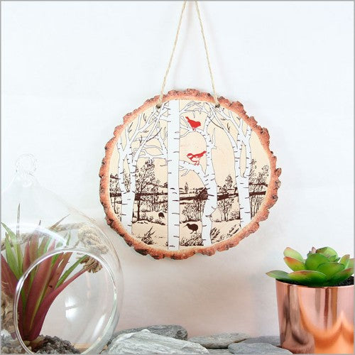 Intricately designed wood slice wall art featuring woodland birds, perfect for rustic or modern decor.