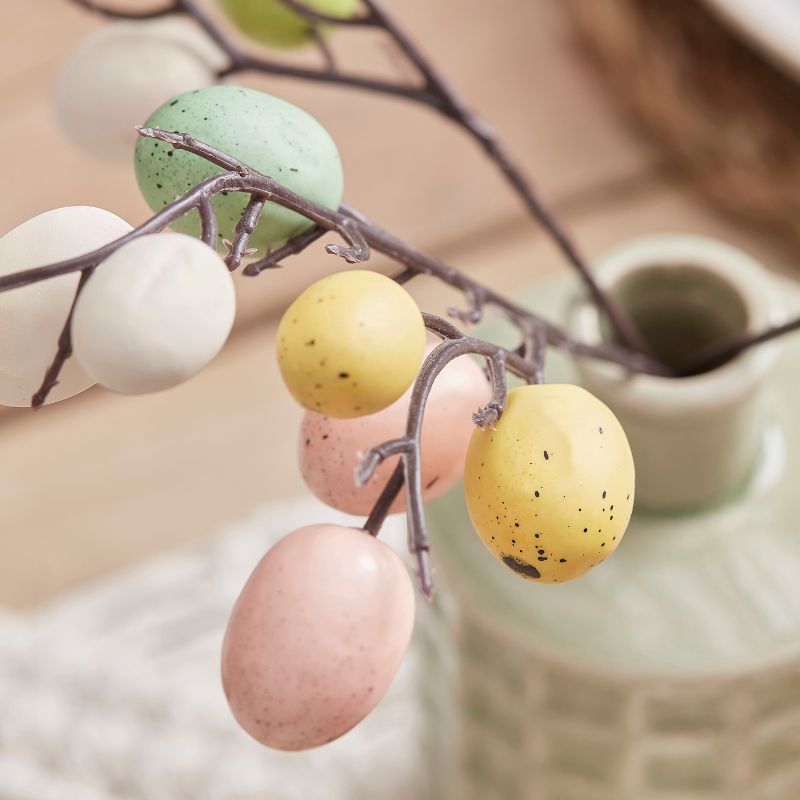 Pastel speckled egg stems for Easter, featuring 5 artificial twigs adorned with colorful plastic eggs, perfect for centerpieces.