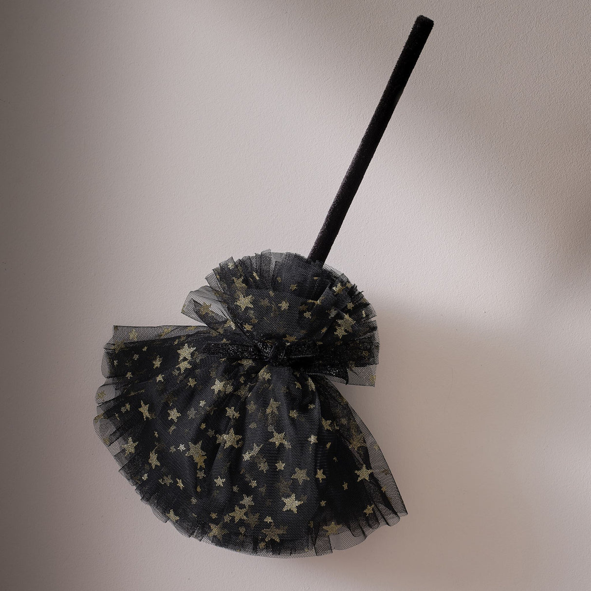 Black and gold star witches broom with tulle base, perfect for Halloween costumes and imaginative play.