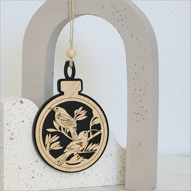 Elegant black satin acrylic hanging ornament featuring a laser-cut huia design, perfect for festive decor and eco-friendly gifting.