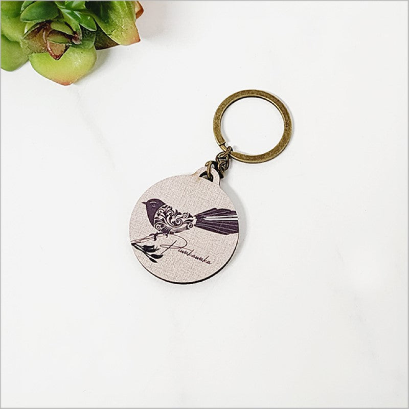Lightweight pine veneer keychain featuring an intricate filigree Fantail design, perfect for adding Kiwiana charm to keys or bags.