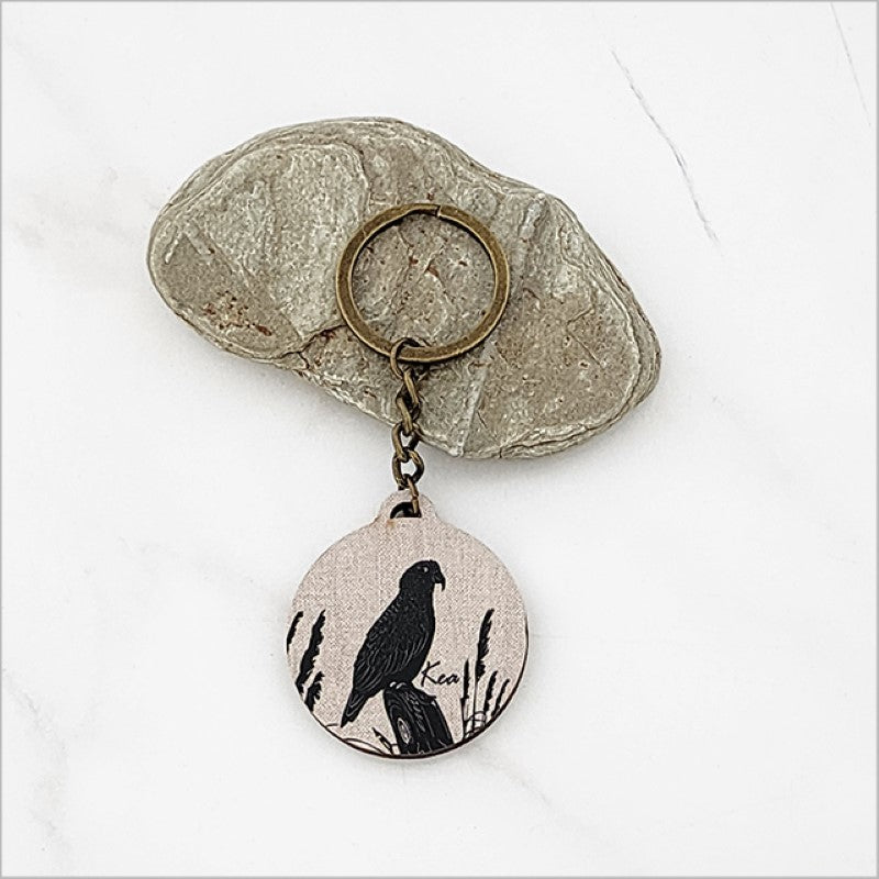 Kea + Toi Toi printed keychain featuring lightweight pine veneer, ideal for stylishly securing keys or bags.