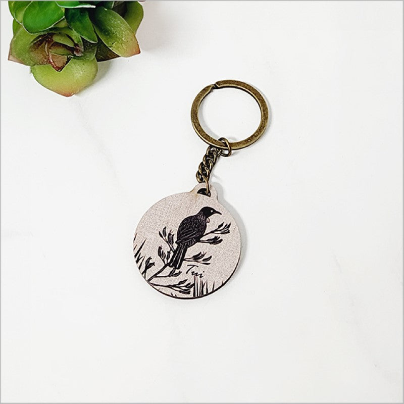 Lightweight pine veneer keychain featuring a Tui bird and flax leaves, celebrating New Zealand's natural beauty.