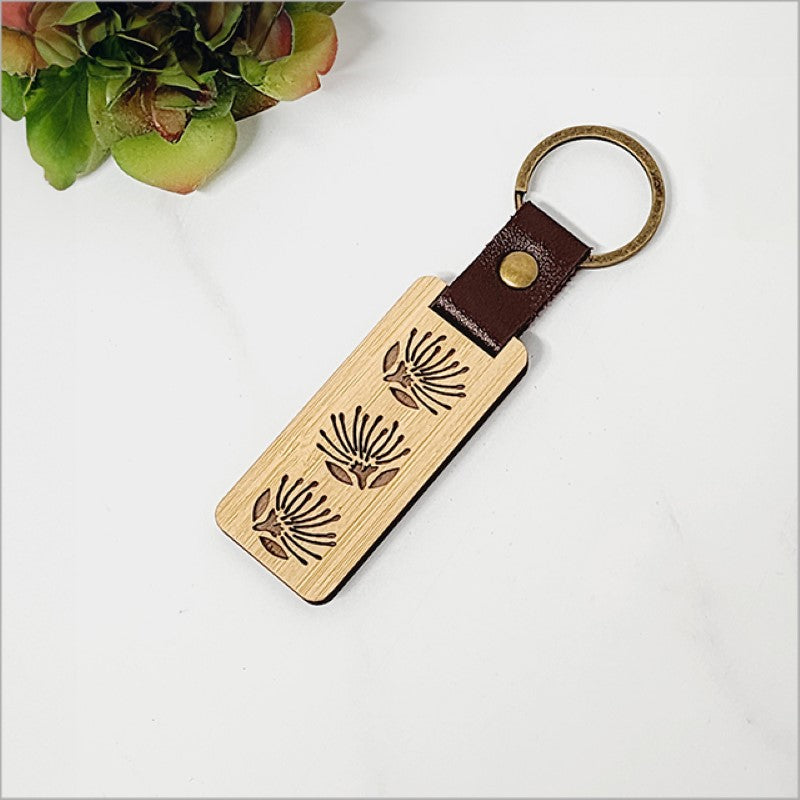 Lightweight bamboo keyring featuring an intricate pohutukawa design, showcasing New Zealand's natural beauty and eco-friendliness.