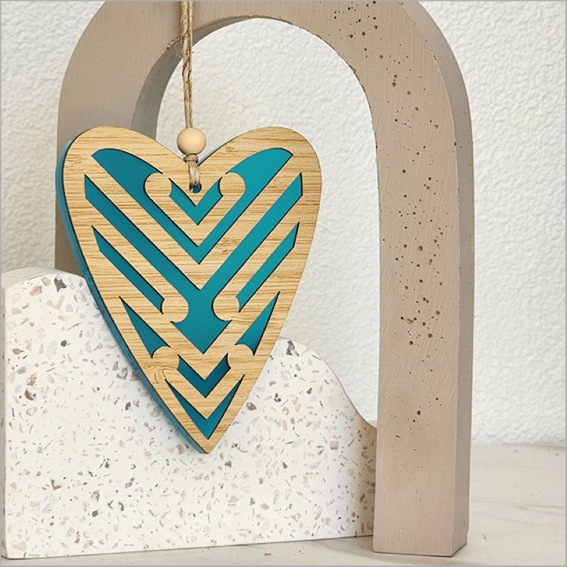 Teal satin acrylic heart ornament with intricate Koru design, ideal for home decor or gifting, measuring 90mm x 105mm x 8mm.