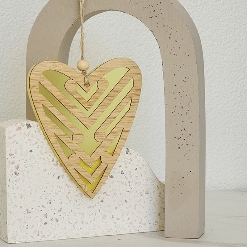 Yellow satin acrylic heart ornament featuring Koru design, ideal for home decor or as a thoughtful gift.