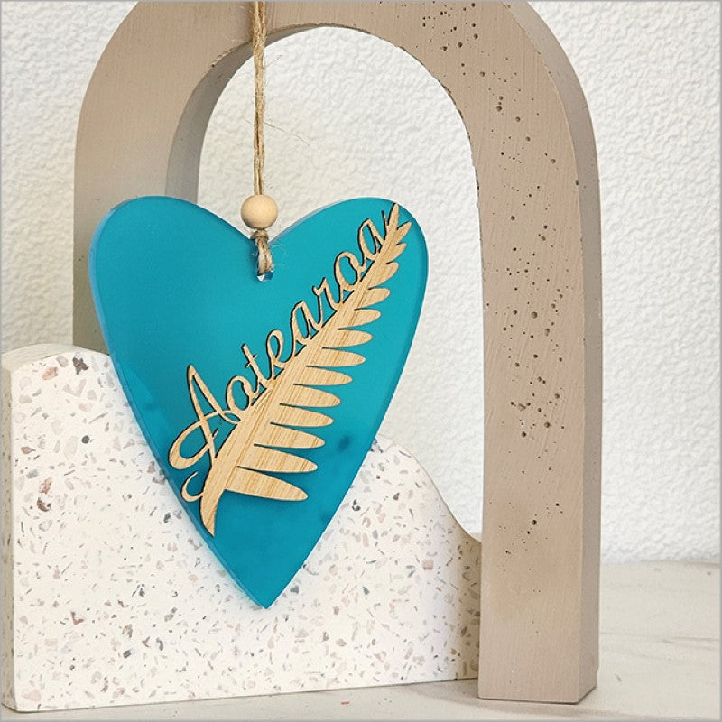 Teal satin acrylic heart ornament featuring silver fern design, perfect for home decor or gifting, 90mm x 105mm.