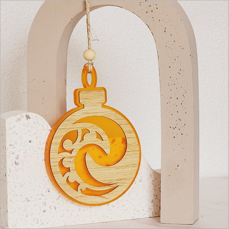 Orange satin acrylic hanging ornament with Koru design, perfect for festive decor and easy gifting.