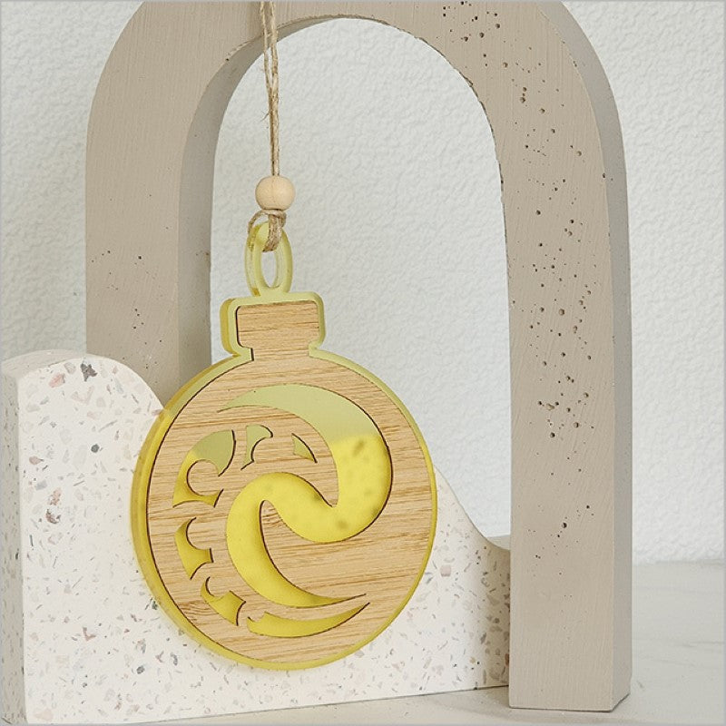 Yellow satin acrylic bauble ornament featuring Koru design, perfect for holiday decor and ready to hang.