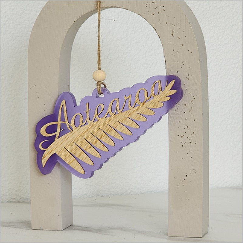 Elegant purple satin acrylic hanging ornament featuring a laser-cut Silver Fern design, perfect for home decor or gifting.