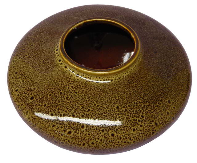 Unique flattened ball-shaped vase in modern design, perfect for flowers or as a standalone decor piece.