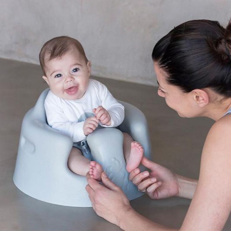 Bumbo Floor Seat in Cool Grey, designed for infants 3-12 months, provides safe, supportive sitting for playtime and bonding.