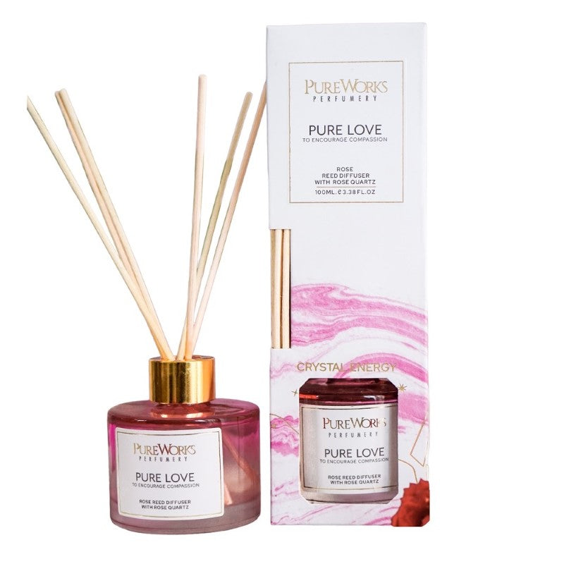 Ombre glass reed diffuser with rose quartz stones, releasing floral scents for love, compassion, and serene home ambiance.