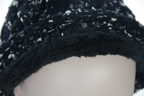 Textured black beanie with fleece lining, fur pom pom, and chic design, perfect for winter warmth and style.