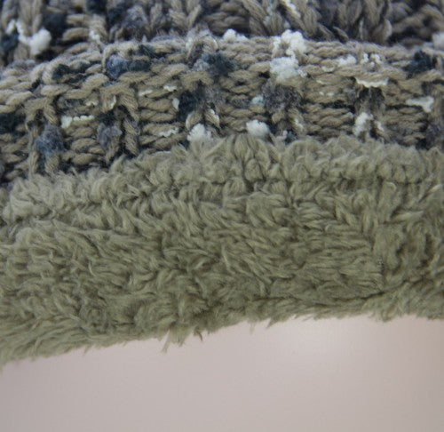 Textured taupe beanie with fleece lining and fur pom pom for warmth and style in cold weather. Perfect winter accessory.