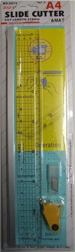 2013 Slide Cutter Set featuring a cutting mat, acrylic ruler with anti-slip backing, and slide cutter for precise crafting.