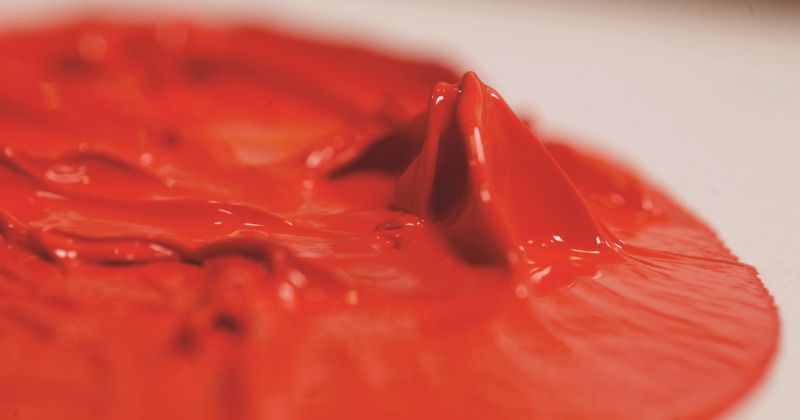 A tube of Liquitex Heavy Body Acrylic paint in Cadmium Free Red Light, featuring a thick, buttery consistency ideal for artists.