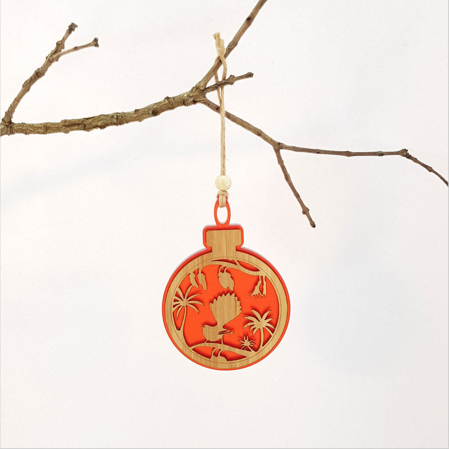 Elegant red satin acrylic bauble featuring a fantail on a kowhai branch, perfect for home decor or Christmas hanging.