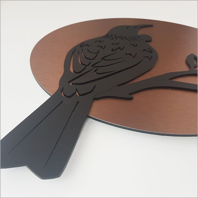 Elegant 37cm brushed copper and black acrylic wall art featuring a Tui design, perfect for any decor style.
