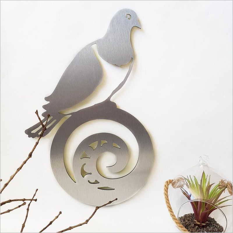 Alt text: Elegant wall art featuring a Kereru on Koru, crafted from brushed silver ACM, ideal for indoor and outdoor decor.