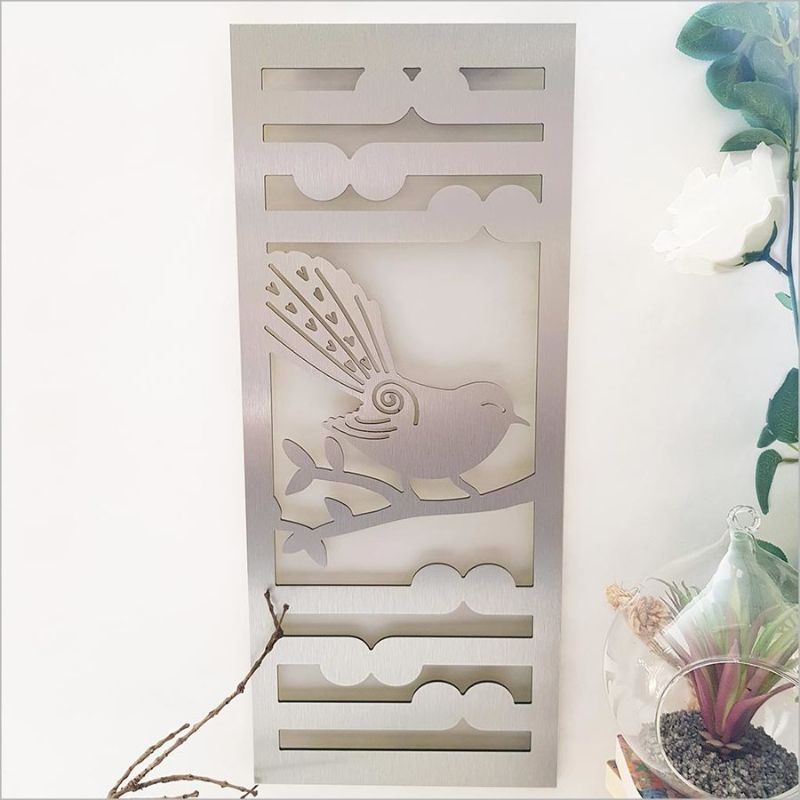 Brushed silver wall art panel featuring fantail and koru motifs, ideal for enhancing indoor or outdoor spaces.