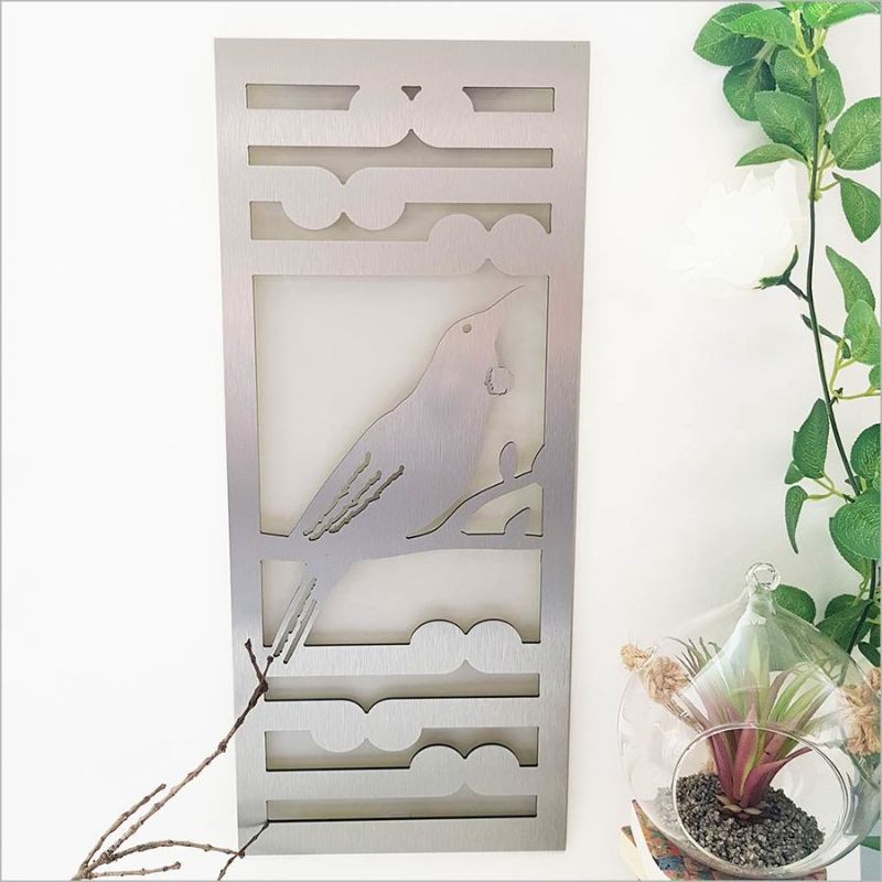 Brushed silver wall art panel featuring Tui and Koru, 55cm tall, ideal for indoor/outdoor decor.