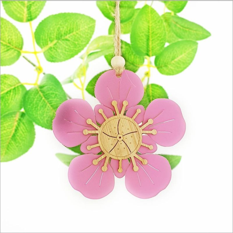 Pink satin acrylic hanging ornament shaped like a Manuka flower, featuring intricate laser cut designs for stylish decor.