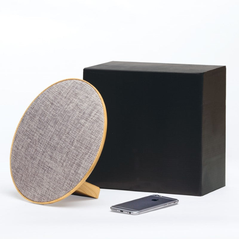 Stylish Lounge Disc Bluetooth Speaker with fabric face and wood grain housing, delivers 10W sound and 4.5 hours playtime.