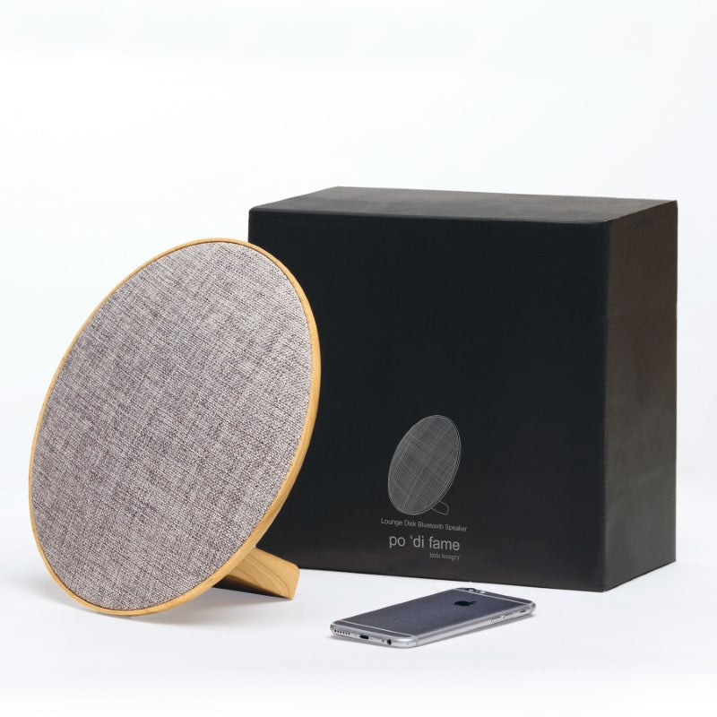 Lounge Disc Bluetooth Speaker featuring stylish wood grain housing, 10W output, and 4.5 hours of playtime.