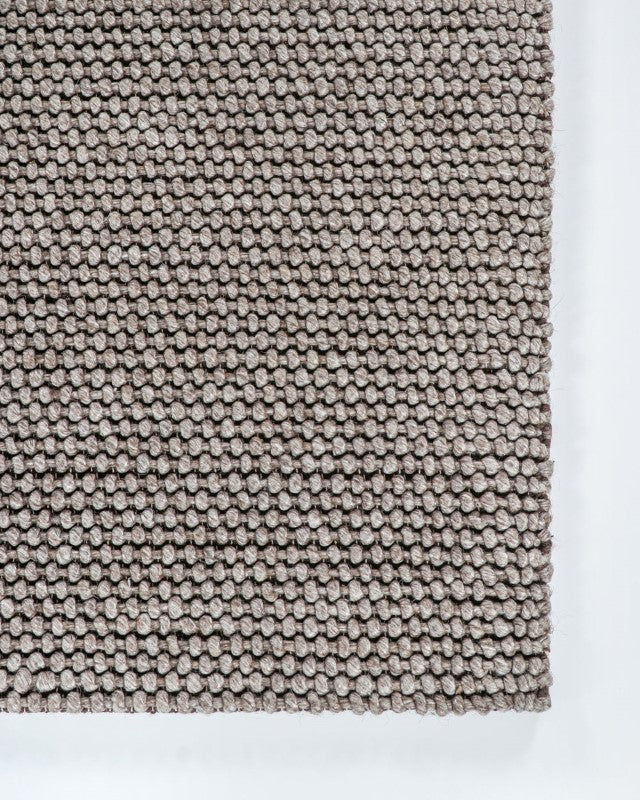 Handwoven 250x350cm beige rug with a knotted weave, combining wool, cotton, and polyester for softness and durability.
