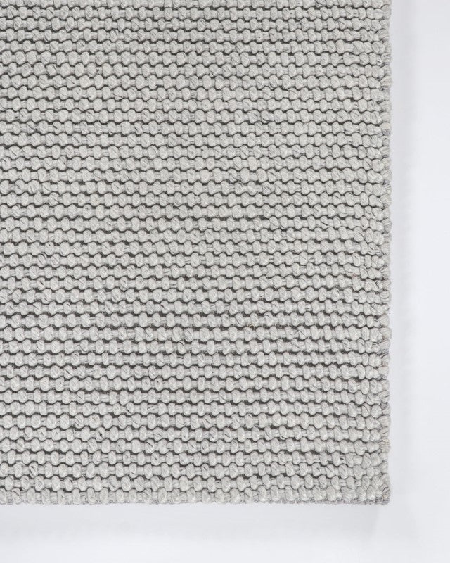 Handwoven beige floor rug measuring 250x350cm, featuring a knotted weave for a soft, luxurious feel in any room.