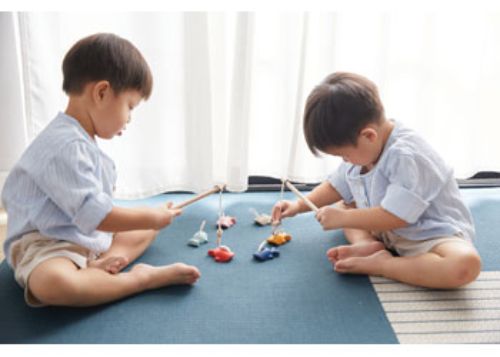 Wooden fishing game for kids featuring magnetic rod and colorful fish, promoting fine motor skills and cooperative play.
