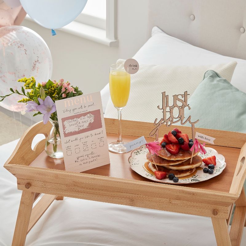 Customisable Breakfast in Bed Set featuring a scratch-to-reveal menu, drink toppers, cake topper, and vibrant balloons.