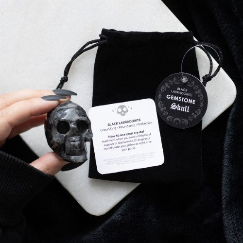 Black Labradorite Crystal Skull, a 4x5x2 cm spiritual accessory for grounding, protection, and decor, in a chic black pouch.