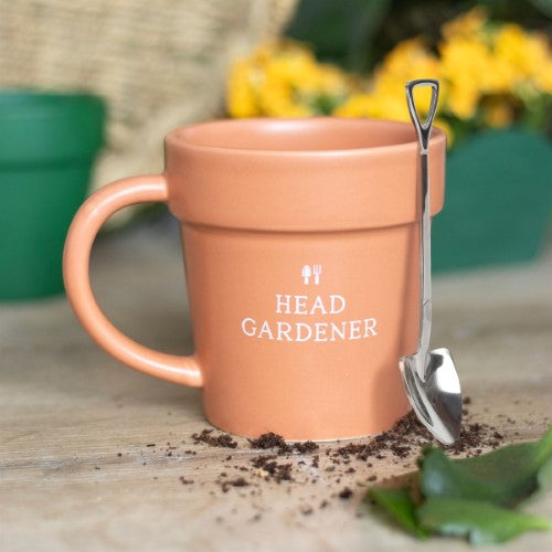 Ceramic plant pot mug with mini shovel spoon, labeled 'Head Gardener,' perfect for enjoying tea or coffee.