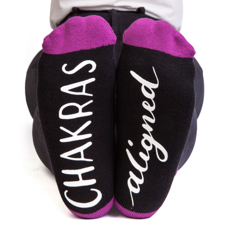 Vibrant Chakra Feet Speak socks with rainbow chakra symbols and anti-slip 'CHAKRAS ALIGNED' for energy and comfort.