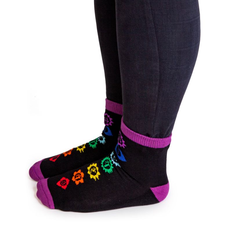 Vibrant rainbow socks featuring chakra symbols and anti-slip 'CHAKRAS ALIGNED' words for style and spiritual expression.