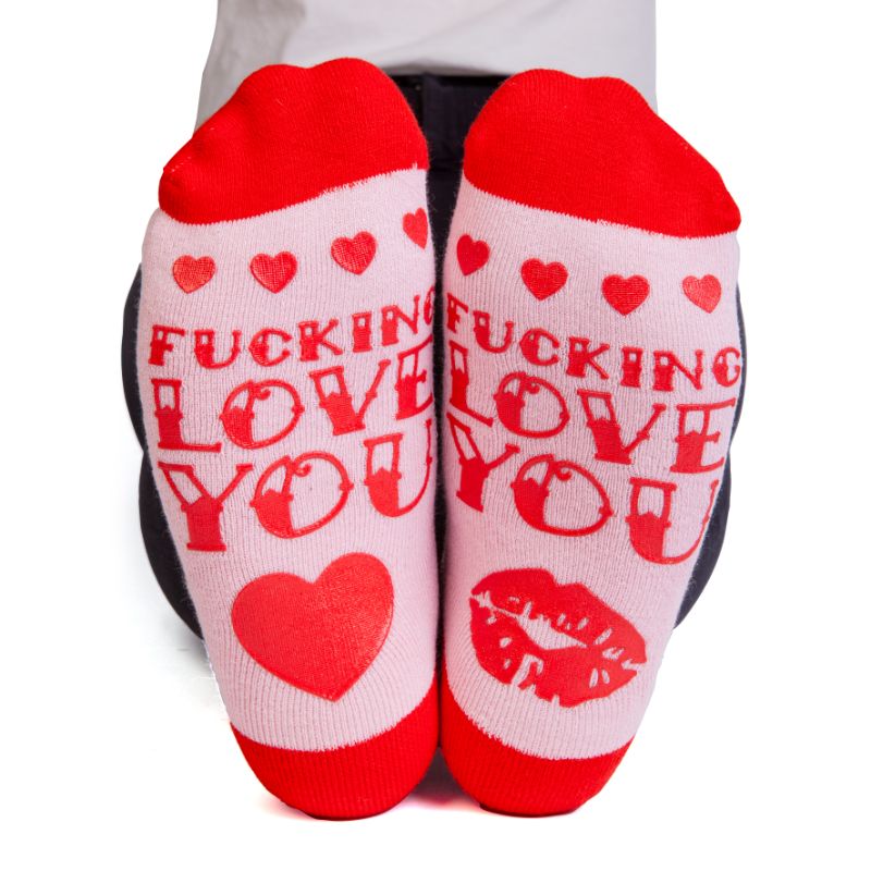 Vibrant pink and red socks with tattoo designs and anti-slip message, perfect for expressing love and cozy style.