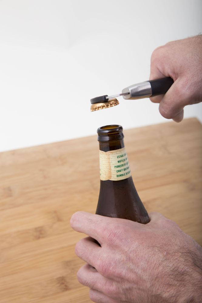 Magnetic bottle opener in stainless steel with a nylon handle, featuring a built-in ring lifter and fridge storage.