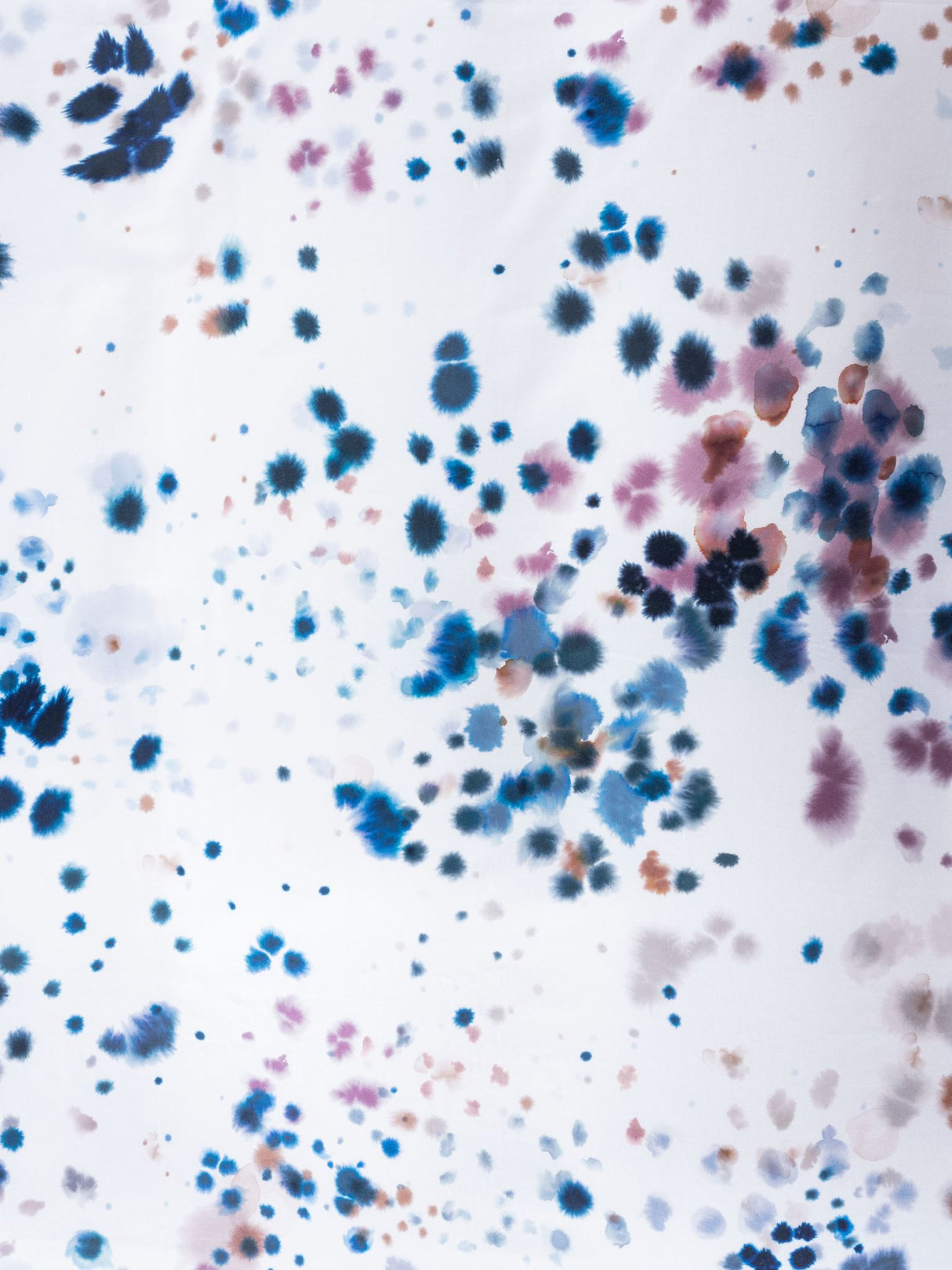 Queen duvet cover set featuring watercolour droplets on white, in rich blues and purples, crafted from soft cotton sateen.