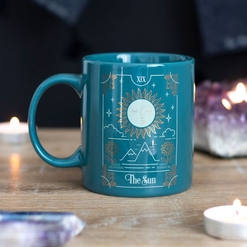 Elegant green ceramic mug featuring The Sun tarot design in white and gold, perfect for coffee, tea, and mystical decor.