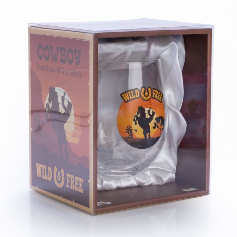 Hand-blown stemless wine glass featuring a cowboy silhouette and 'Wild & Free' lettering against a vibrant sunset backdrop.